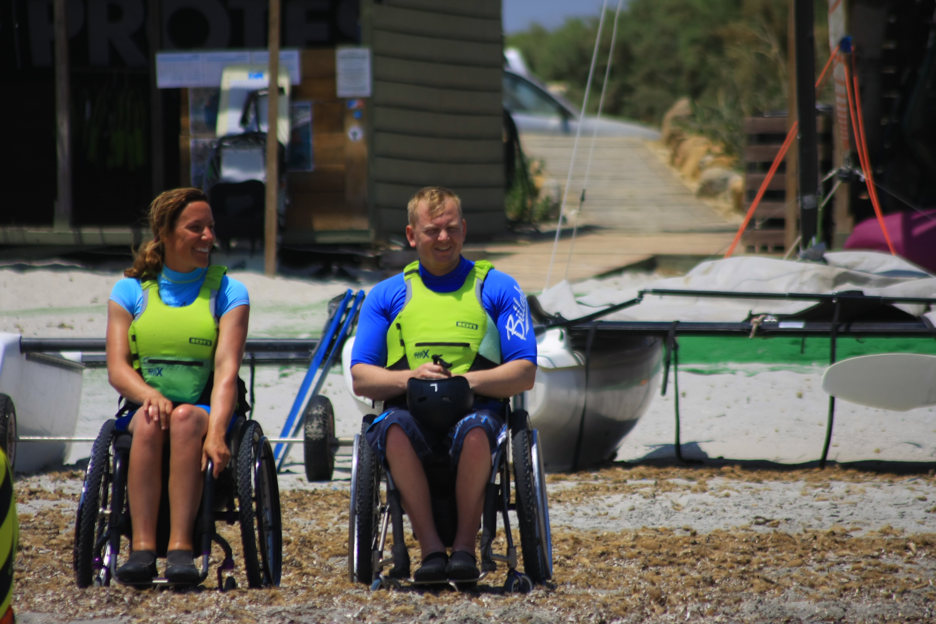 Two participants in wheelchairs at Surf Club Keros, ready for adaptive water sports